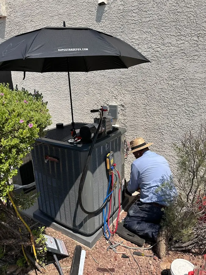 HVAC technician performing outdoor AC maintenance in Maumee